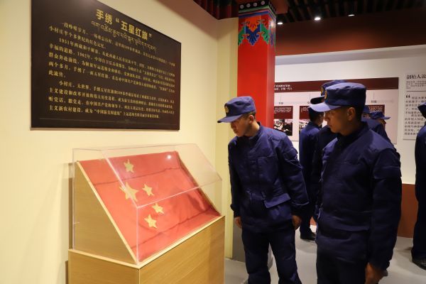 03301774869159672042.jpg 图为消防员驻足观看手绣五星红旗.JPG