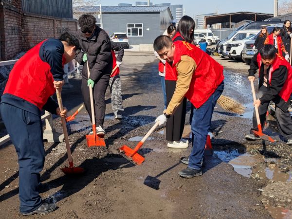 04011775041986685225.jpg 志愿者们在填补道路坑洼-金雯晴摄.jpg
