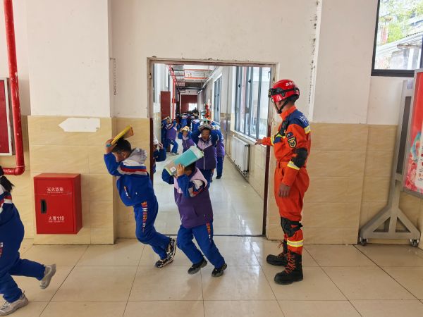 05131778667936542965.jpg 在消防救援人员的指导下开展应急疏散演练.jpg