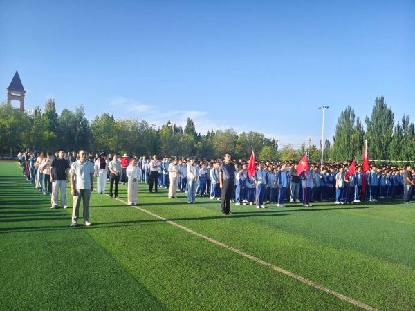 三团中学师生在体育场进行升旗仪式.jpg